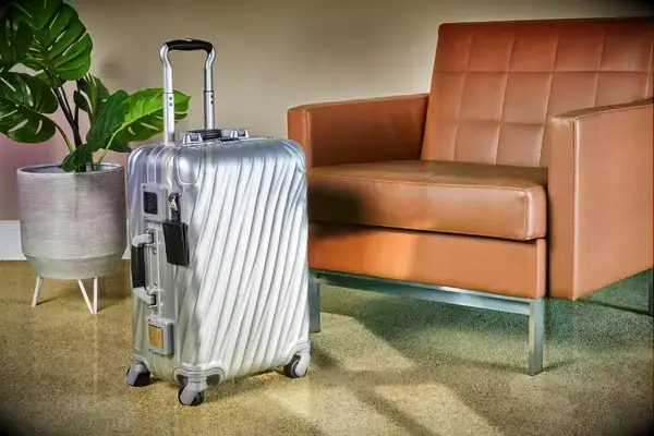 A Tumi carry-on in front of a chair