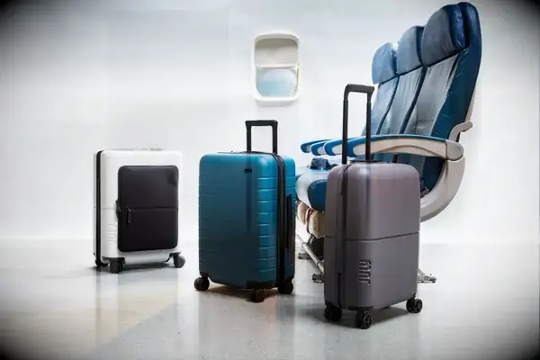 Three pieces of luggage near airplane seats and window