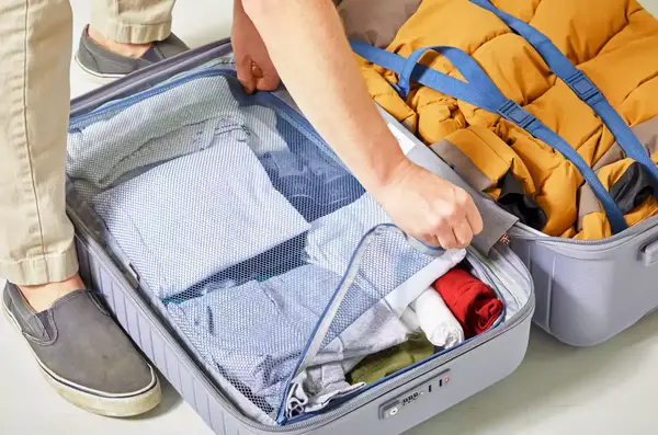 A hand zippering a compartment inside of the Delsey Paris Cruise 3.0 26 Inch Trunk