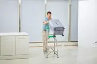 A person pushing the Delsey Paris Cruise 3.0 26 Inch Trunk off of a ladder