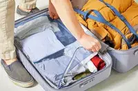 A hand zippering a compartment inside of the Delsey Paris Cruise 3.0 26 Inch Trunk