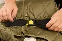 A person secures a strap on the Delsey Paris Cruise 3.0 Soft Carry-On Expandable Spinner