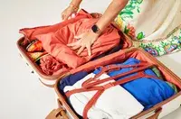 A person packing a Delsey CHATELET AIR 2.0 CARRY-ON - 21