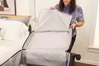 A person unzips the Delsey Paris Cruise 3.0 Soft Large Expandable Spinner