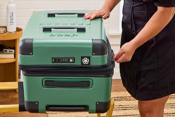 A person zips the Delsey X Jeep JH002B Large Expandable Spinner Trunk closed