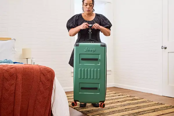 A person weighs the Delsey X Jeep JH002B Large Expandable Spinner Trunk