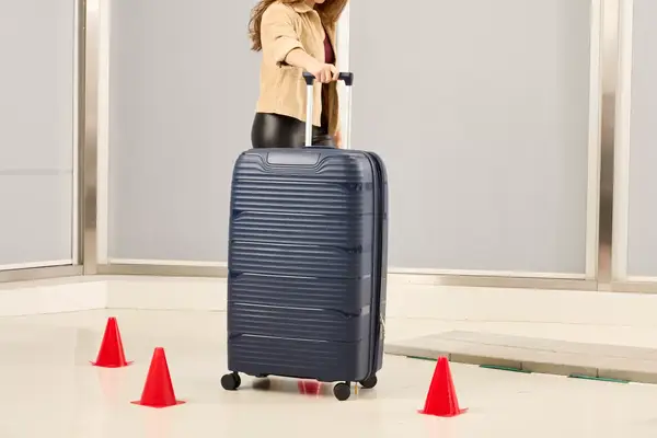 A person rolls the Delsey Paris Dune Large Expandable Spinner over a floor
