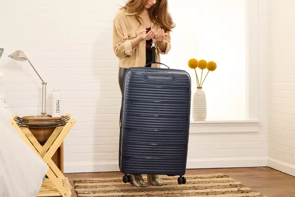 A person weighs the Delsey Paris Dune Large Expandable Spinner