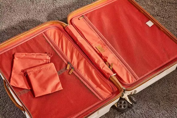 Delsey Paris Chatelet Air 2.0 24 Inch Checked Spinner laying empty on a carpet