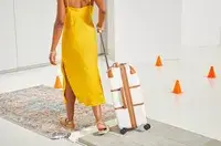 Delsey Paris Chatelet Air 2.0 24 Inch Checked Spinner being rolled on tile