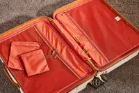 Delsey Paris Chatelet Air 2.0 24 Inch Checked Spinner laying empty on a carpet