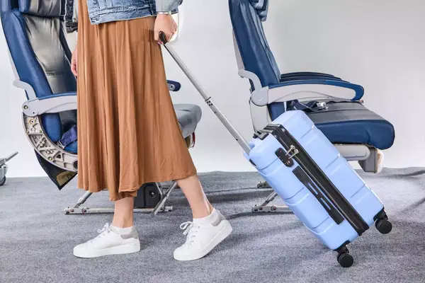 A person wheeling the DELSEY PARIS X United Colors of Bennetton Carry-on Spinner
