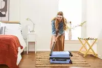 A person hitting the DELSEY PARIS X United Colors of Bennetton Carry-on Spinner with a bat