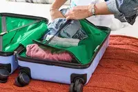 A person packing the DELSEY PARIS X United Colors of Bennetton Carry-on Spinner