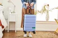 a person using a luggage scale on the DELSEY PARIS X United Colors of Bennetton Carry-on Spinner