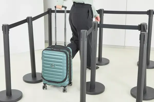A person wheels the Delsey Paris Shadow 5.0 Carry-on with Laptop Compartment through line markers