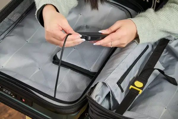 A person adjusts the lock on the Delsey Paris Shadow 5.0 Carry-on with Laptop Compartment