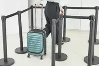 A person wheels the Delsey Paris Shadow 5.0 Carry-on with Laptop Compartment through line markers