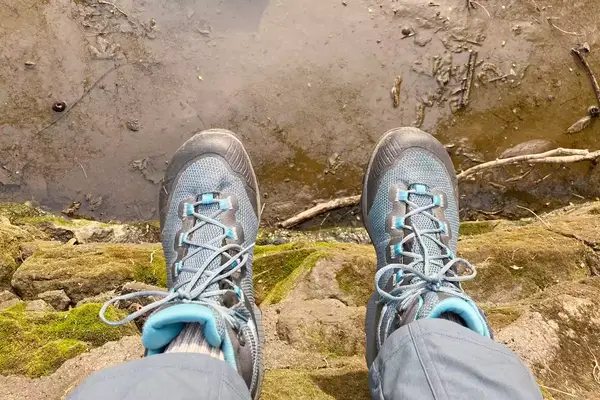 A person sits from a ledge while wearing La Sportiva TX Hike Mid GTX Hiking Boots
