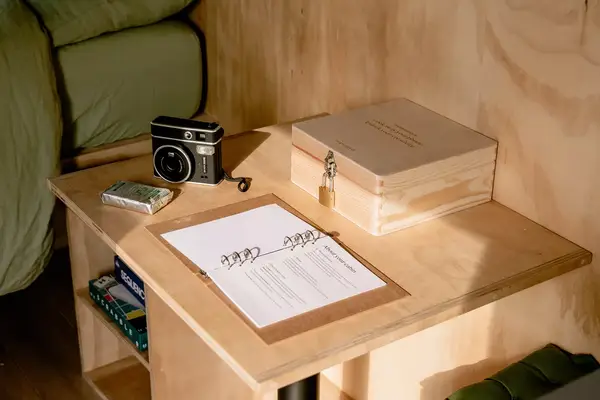 A lockbox, camera, and rule book on a wooden countertop