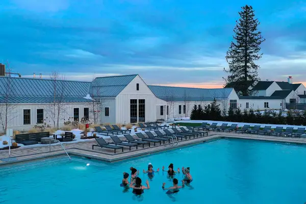 People stand together in a outdoor pool in the winter