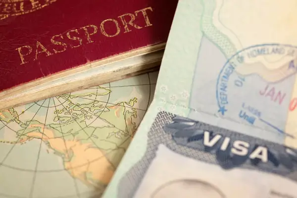 Close up of edges of a passport and a map in the background