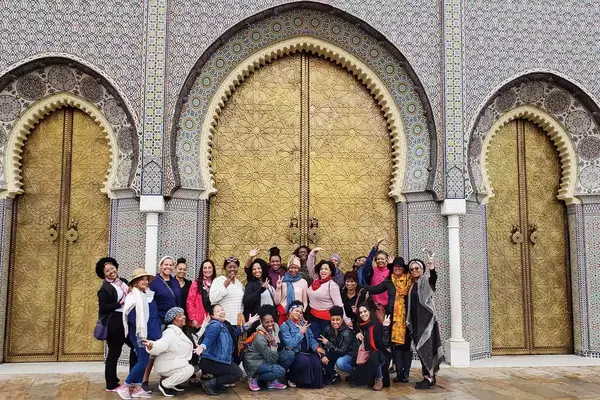 A group of women in front of a tiled facade in Fez, Morocco