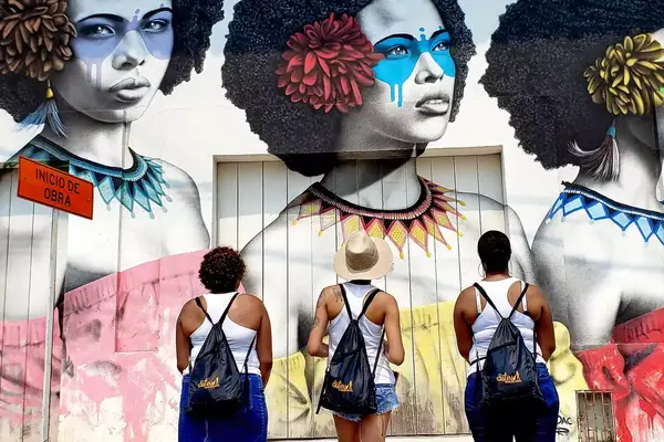Three women looking at street art in Cartagena, Colombia