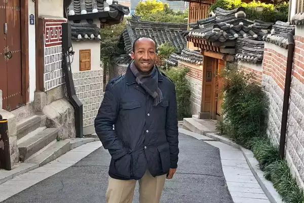 Travel advisor Kareem George poses for a photo on a small street in Seoul, Korea