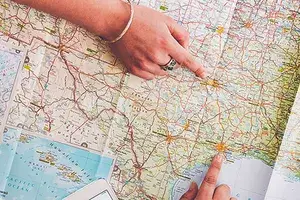 Women planning trip with map on wooden table