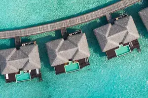 aerial top view overwater villas in lagoon of tropical island