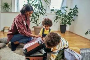 A mom with two children packing a suitcase for a trip