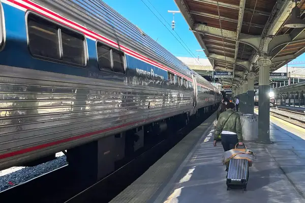 A woman rolling her luggage on an Amtrak platform in Washington DC