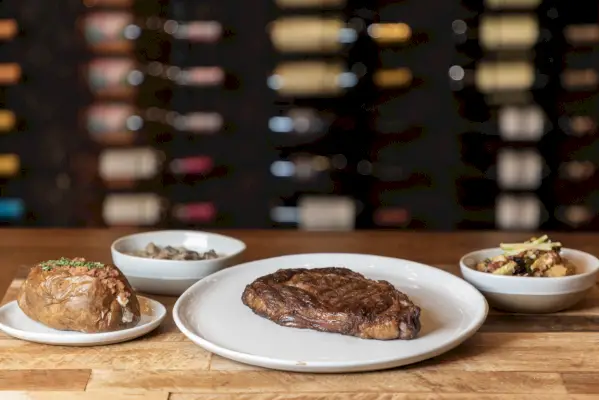 an array of dishes at westgate river ranch include steak, a loaded potato, vegetables and more