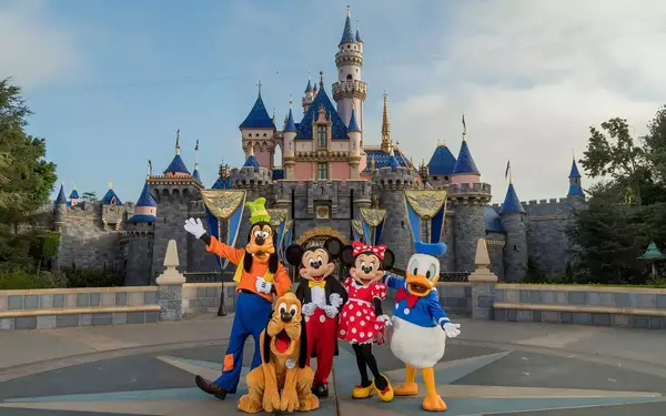 The Disney characters, Goofy, Pluto, Mickey, Minnie and Donald Duck in front of the castle at Disneyland in California