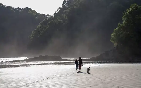 Father and son walking on the beach at sunset, Nuqui Beach, Colombia