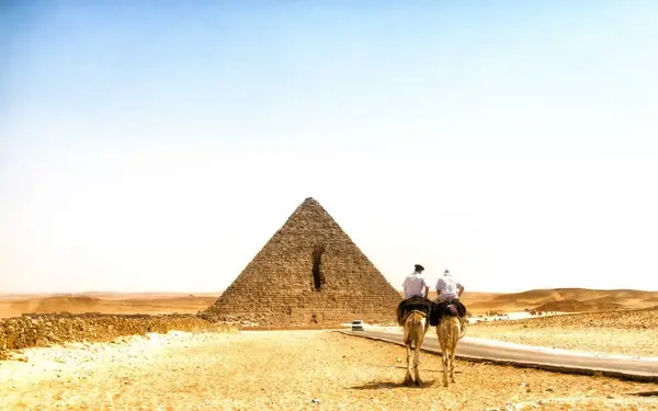Two policemen on camels in front of the Pyramids in Giza, Egypt
