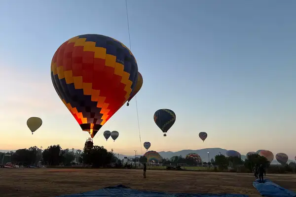 Hot air balloons being filled in Mexico City during sunrise 