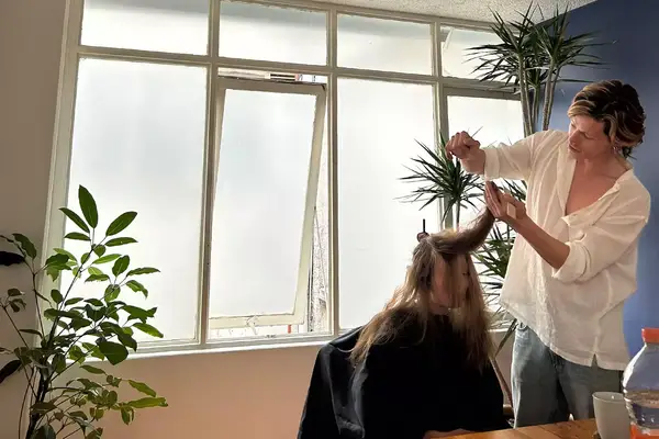 A woman getting a haircut in an airbnb in Mexico City