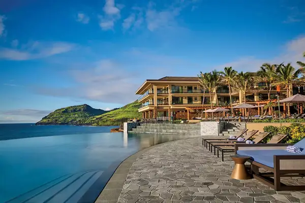 Infinity pool with ocean view and lounge chairs at Timbers resort in Kauai
