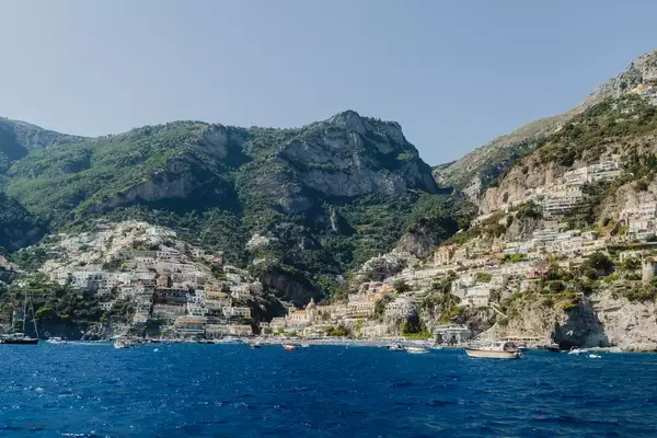 A coastal town with hillside buildings beside blue water