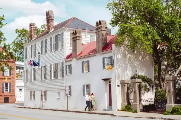 A couple dressed up walks down the streets of Charleston
