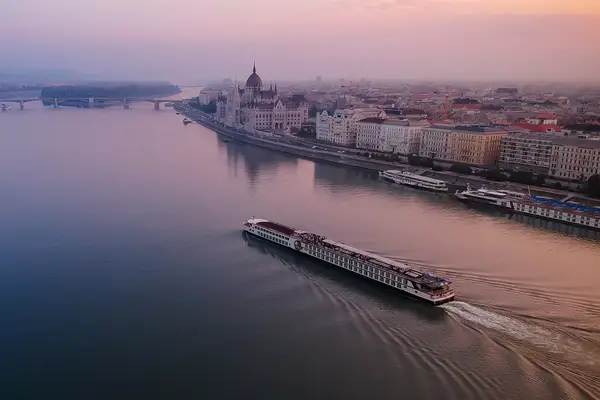 A river cruise is about to go past the Hungarian Parliament Building on the Danube river