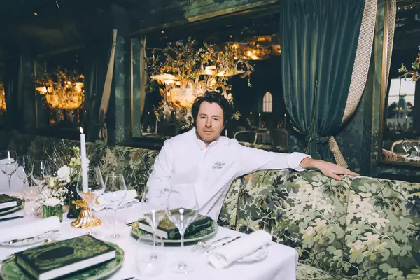 Chef Jean Imbert sitting at a banquette in his Disneyland Paris restaurant