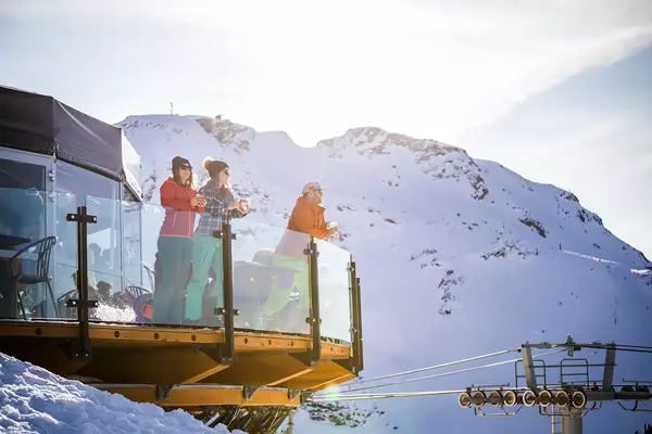 Group of friends enjoying apres-ski at top of Whistler mountain.
