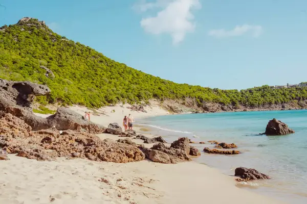 A couple walking along Colombier beach in St Barts