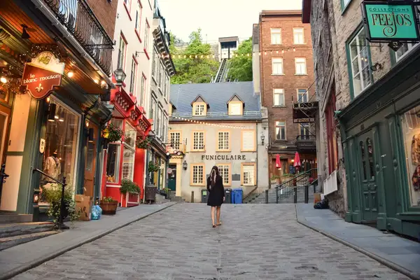 A woman walking on a cobble stone street in Quebec City