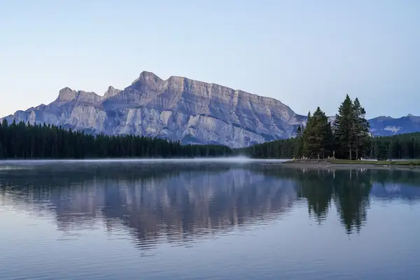 Mountain landscape with trees reflected in a calm lake