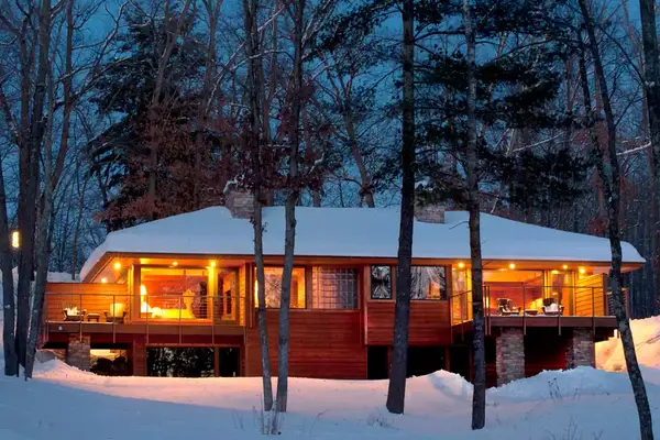 A nighttime exterior shot shows a wooden lodge building at Wisconsin