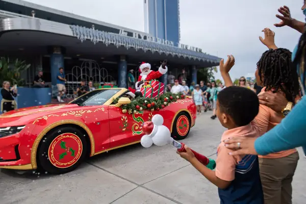 Santa riding in a convertible car in a parade